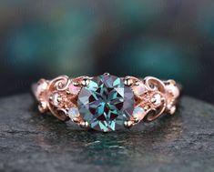 an engagement ring with a blue topazte surrounded by white and rose gold filigrees