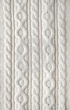 a white knitted blanket is shown in close up