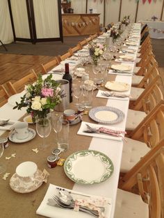 a long table is set with place settings and wine glasses