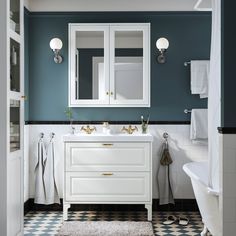 a bathroom with blue walls and white cabinets, black and white checkered flooring