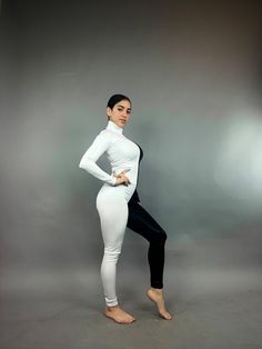 a woman in white and black is posing for the camera with her hands on her hips