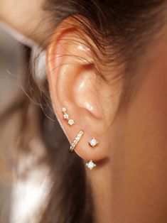 a woman wearing three different ear piercings on her left and right side of the ear