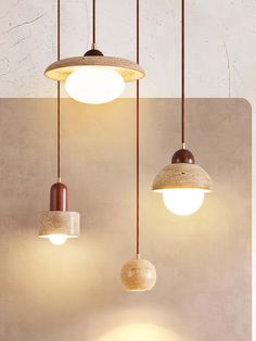 three different lights hanging from the ceiling in a room with concrete walls and flooring