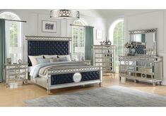 a bedroom scene with focus on the bed, dressers and mirror cabinetry in the room