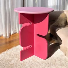 a pink table sitting on top of a white rug