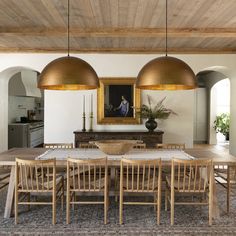 a dining room table with six chairs and a large painting on the wall behind it