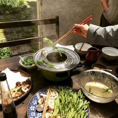 a table topped with plates and bowls filled with food next to chopsticks on top of each plate