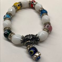 This Beautiful Brand New Multi Color Evil Eye And White Glass Beaded Stretch Glass Bracelet With Cubic Zirconia. It Is Made Of Top Quality Materials And Authentic Approx Measurements 8" Hanging Evil Eye Charm Promotes Good Luck, Healing And Defends Against Negative Energy White Spiritual Bracelets With Colorful Beads, Spiritual White Bracelets With Colorful Beads, White Beaded Crystal Bracelets, Adjustable White Evil Eye Bracelet With Colorful Beads, White Adjustable Beaded Bracelets With Evil Eye, Adjustable White Beaded Bracelets With Evil Eye, White Stretch Bracelet With 8mm Beads, White Spiritual Stretch Bracelet With Large Beads, White Crystal Bracelet With Colorful Round Beads