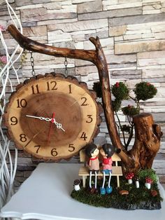 a wooden clock sitting on top of a table next to a tree stump and small figurines