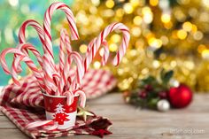 some candy canes are in a cup on a table