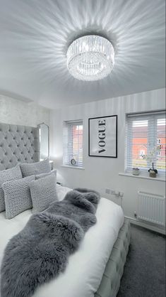 a bedroom with a large bed and chandelier