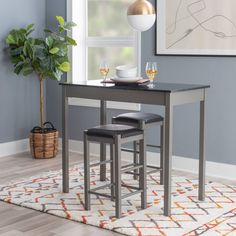 a dining room table with two stools next to it