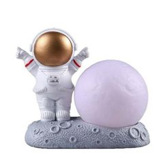 an astronaut figurine next to a white ball