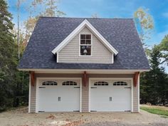 a two car garage with three windows on the front and one above the garage door