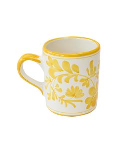 a yellow and white coffee cup with flowers on it's rim, sitting against a white background