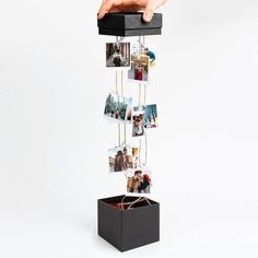 a hand holding a black box with pictures hanging from it's sides and the words 12 photos below