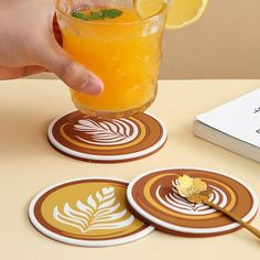 a person is holding a drink in front of some coasters