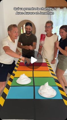 a group of people standing around a colorful table