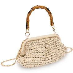 a straw bag with bamboo handles and chain straps on the handle, sitting on a white surface