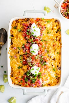 an enchilada casserole with sour cream and green onions on top