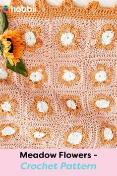 a crocheted blanket with sunflowers on it and the words meadow flowers written in