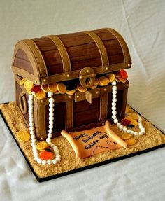 a birthday cake made to look like a pirate's chest with gold coins and pearls