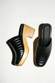 Slip on, quilted leather clogs with a hand carved wooden base. 2.5" base with 100% leather upper and lining.