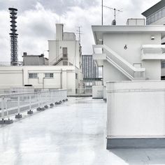 an empty rooftop with white walls and balconies