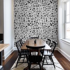 a dining room with a table and chairs in front of a wallpapered wall