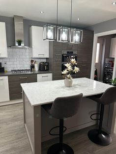 a kitchen with two stools and a center island