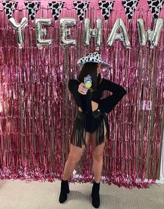 a woman standing in front of a pink backdrop with the words yeehaw on it