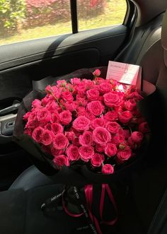 a bouquet of pink roses in the back seat of a car