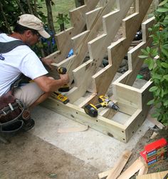 a man working on some wooden boards in the woods