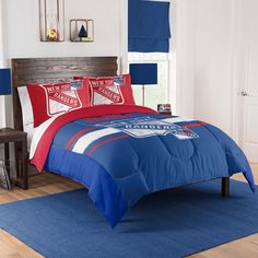 a bedroom with blue and red bedding in it