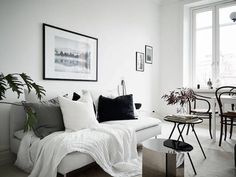 a living room filled with furniture and a white couch in front of a large window