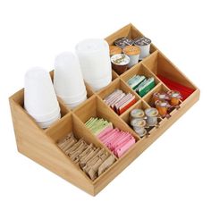 a wooden tray with compartments filled with food and drinks on top of each other,