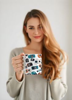 a woman holding up a mug with cameras on it