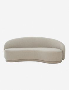 the curved sofa is made from fabric and has an upholstered back, with a rounded