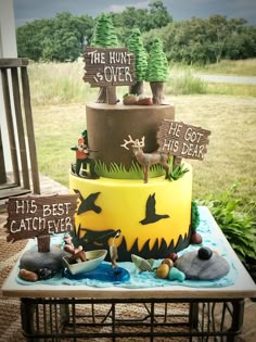 a three tiered cake with wooden signs on the top and decorations in the middle