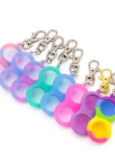 several different colored pacifiers are lined up in a row on a white background