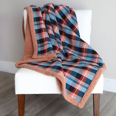 a plaid blanket sitting on top of a white chair