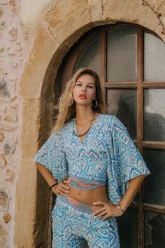 Bohemian  Cropped Top with a Wrap Cut, to Tie in Front or in the Back, Flair Ombrella Sleeves Style. This Top is Light and Does Not Wrinkle, It is Made of Polyester. Its Touch is Soft Like Silk But It Is Much Easier to Care. Light and Comfortable Fabric with Colorful Prints, Making It  The Ideal Summer Top For The Beach, a Party or When Traveling Free Size from S to XL Main Color: White Print Colors: Blue Machine wash 30o No dryer Delivered In A Cloth Pouch And Wrapped In Tissue Paper Ideal For Summer Printed Tunic Sets, Printed Tunic Sets For Summer, Blue V-neck Vacation Sets, Summer Vacation Tunic Sets, Multicolor Summer Tunic Sets, Bohemian Multicolor V-neck Sets, Patterned Sets For Beach, Patterned Beach Sets, Bohemian Printed Top For Vacation