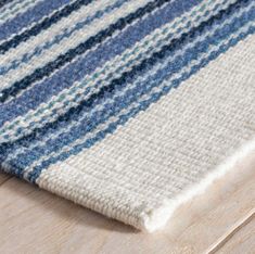 a close up view of a blue and white rug on a wooden floor with wood grain