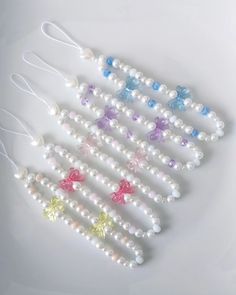 several beads with bows are arranged on a white surface