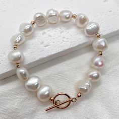 Add a touch of elegance to your outfit with our Baroque pearl bracelet. This bracelet is both elegant and versatile, making it perfect for both casual and formal events. The unique shape of the baroque pearls adds a touch of whimsy to any outfit, while the gold-filled findings provide a classic and timeless feel. D E T A I L S *  14K Gold Filled. *  Pearl is genuine freshwater baroque pearl. *  Pearl measures 9-10 mm. *  Tarnish-free and safe for sensitive skin. C R A F T I N G  *  S H I P P I N G *  We handcraft each piece to order, so please allow 3-5 business days for processing before shipment. *  Orders typically ship via USPS First Class Mail and arrive within 2-5 business days within the US.  R E T U R N  *  E X C H A N G E *  We want you to be completely satisfied with your purchas Elegant Single Strand Baroque Pearl Bracelet, White Baroque Pearl Bracelets For Formal Occasions, Formal White Baroque Pearl Bracelets, Elegant Single Strand Baroque Pearl Bracelets, Classic Baroque Pearl Bracelet For Formal Occasions, Classic Baroque Pearl Bracelets With Oyster Clasp, Classic Baroque Pearl Bracelets With Oyster Detail, Classic Baroque Pearl Bracelets, Classic Round Baroque Pearl Bracelet