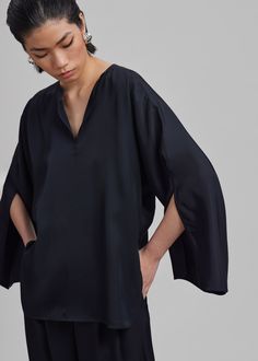 Color: Black Lightweight fluid fabric Relaxed fit V neckline Split dolman sleeves Slip on style Unlined 100% Acetate Machine Wash Cold By Malene Birger. Imported Elegant Silk V-neck Tunic, Silk Top With Draped Sleeves For Work, Silk Tops With Draped Sleeves For Work, Silk V-neck Top With Blouson Sleeves, Chic V-neck Tunic For Workwear, Elegant Oversized V-neck Top, Evening V-neck Top With Blouson Sleeves, Oversized Silk Tops, Chic Blouse With Kimono Sleeves For Work