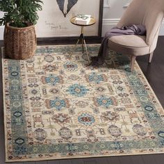 a large rug with an ornate design on the floor in front of a chair and potted plant