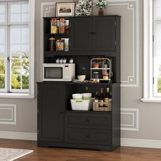 a kitchen cabinet with many items on it in front of two windows and a rug