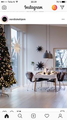 a christmas tree is in the middle of a room with white walls and wooden floors