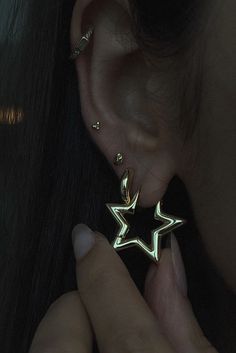 a close up of a person's ear with a star shaped earrings on it